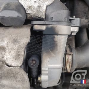 Info Technique : contre-pression dans la ligne d’échappement sortie turbo, Le turbo a été remplacé mais des gaz d'échappement s'échappent par la partie centrale, côté échappement plus précisément. Cette photo montre les conséquences d'une ligne d'échappement sortie turbo partiellement ou complètement colmatée (catalyseur, filtre-à-particules, etc), les gaz sous pression ne sont pas évacués, une pression s'installe et les gaz cherchent une issue au travers du turbo et des brides de fixation. Au bout d'un temps, de la suie se dépose un peu partout sur le turbo et dans la baie moteur, à terme, c'est la casse du nouveau turbo.